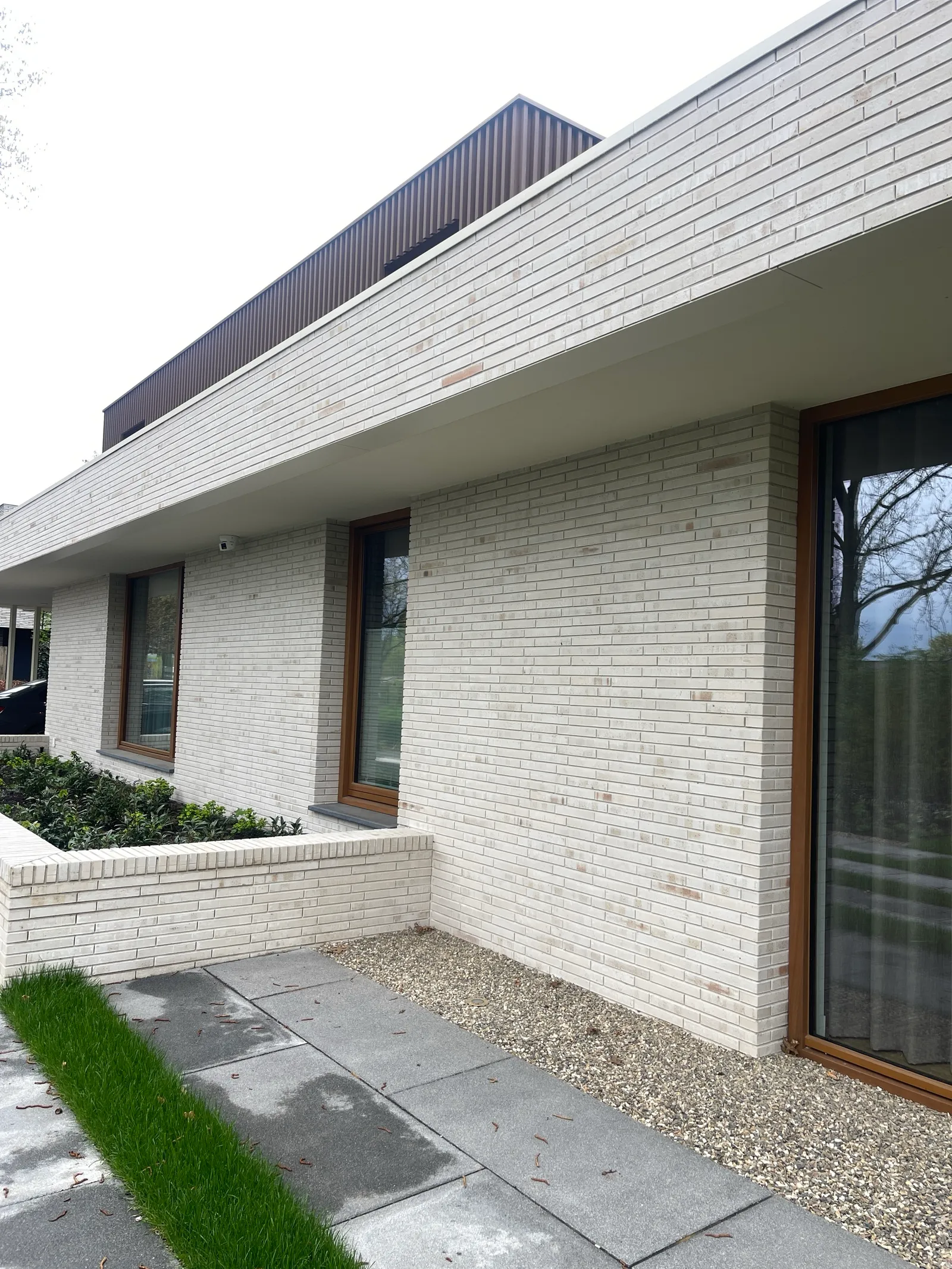 Gerenoveerde lichte baksteengevel met donker dak